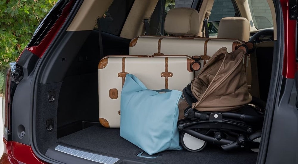 Luggage is shown in the trunk of a red 2023 Cadillac XT6.