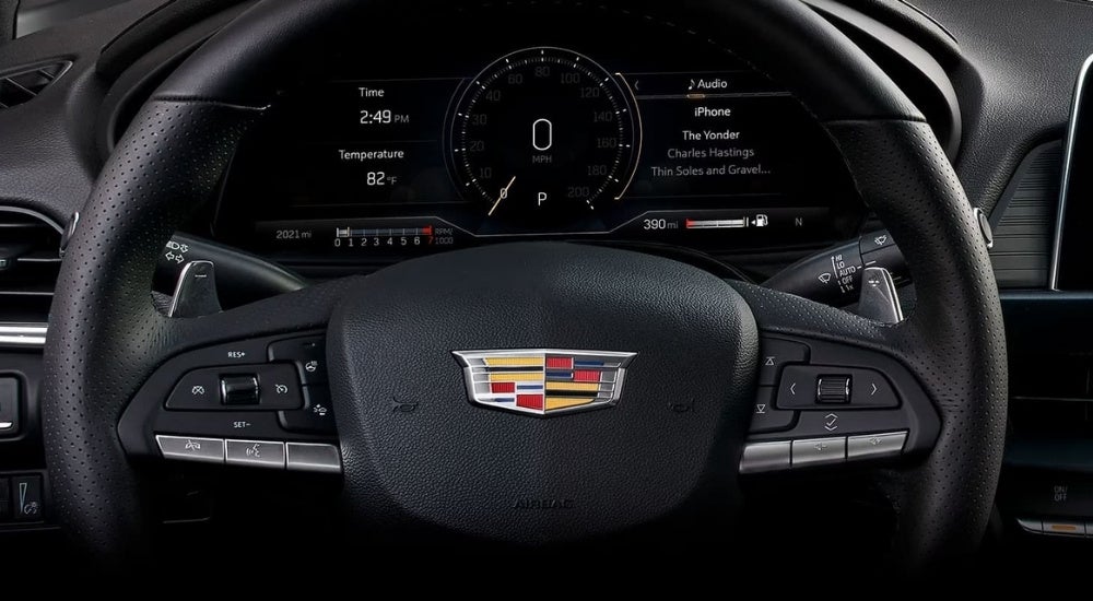 A close-up shows the black steering wheel in a 2023 Cadillac CT4.