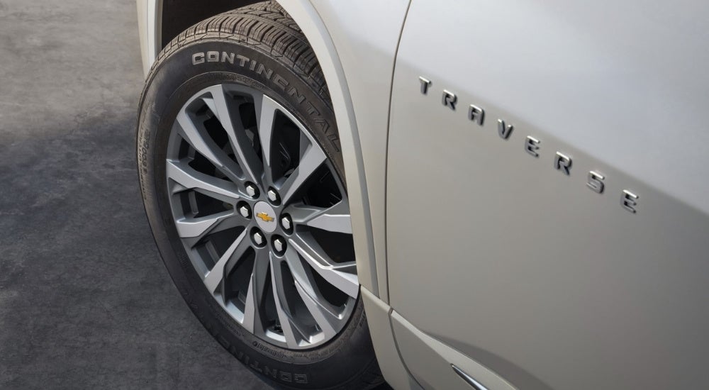 A close up shows a silver wheel on a grey 2022 Chevy Traverse.