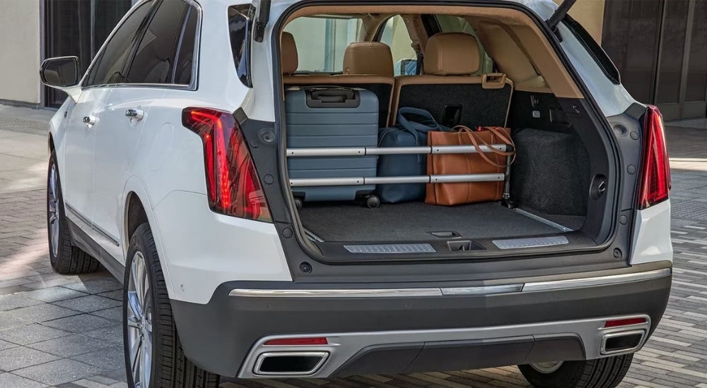 Luggage is shown in the trunk of a white 2023 Cadillac XT5.