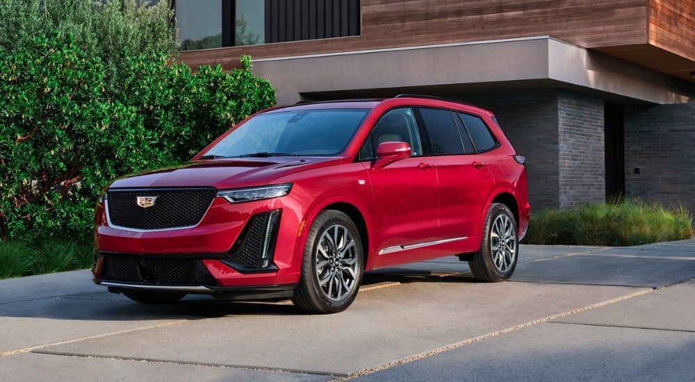 A red 2021 Cadillac XT6 is shown parked on a driveway.