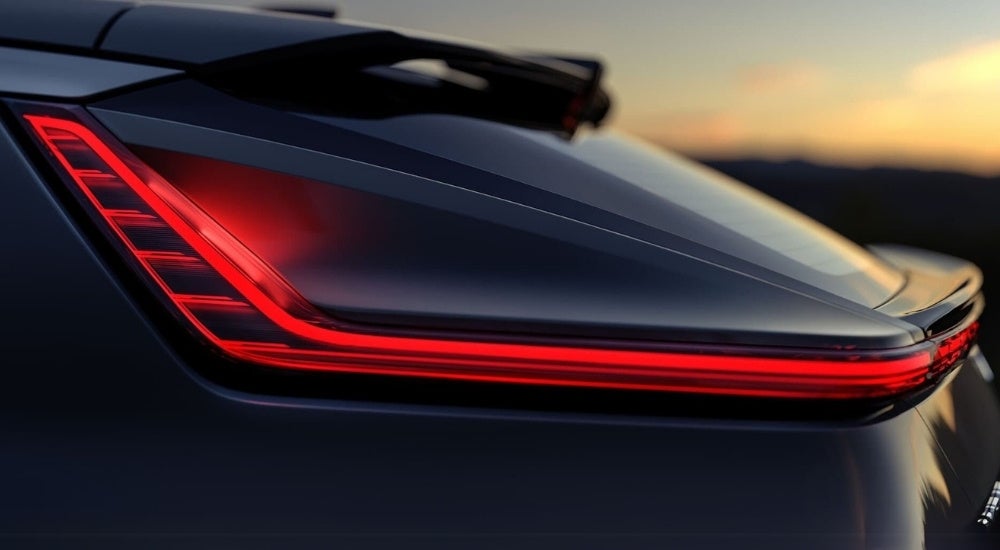 An illuminated taillight is shown on a black 2024 Cadillac LYRIQ.