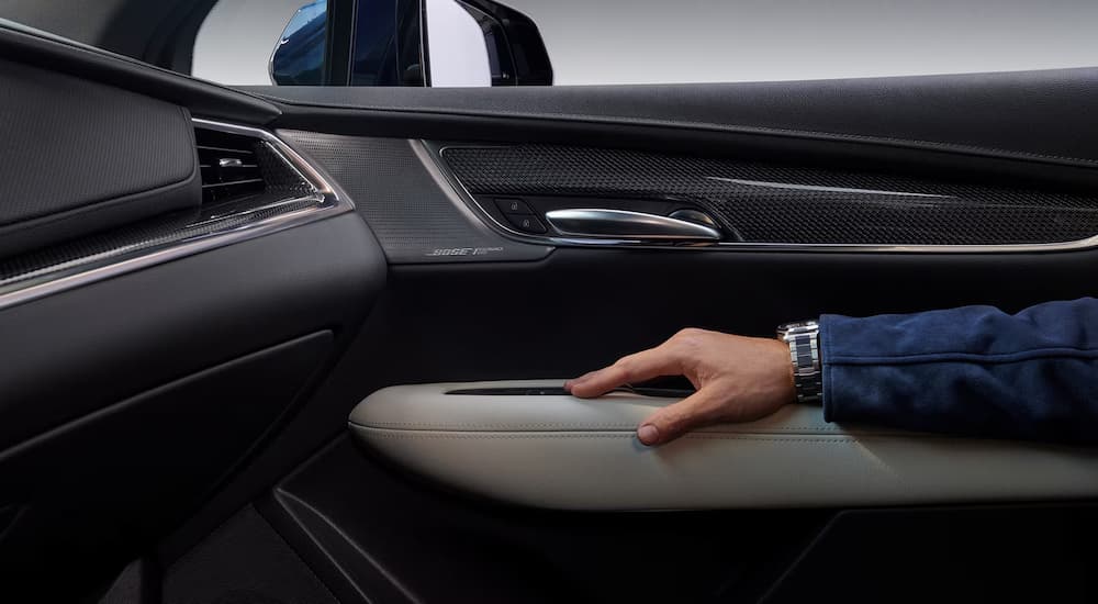 A man resting an arm on the door of a 2025 Cadillac XT5.