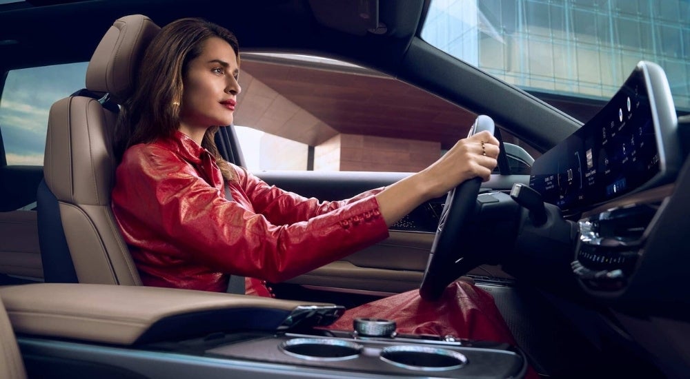 A person is shown driving a 2024 Cadillac LYRIQ.