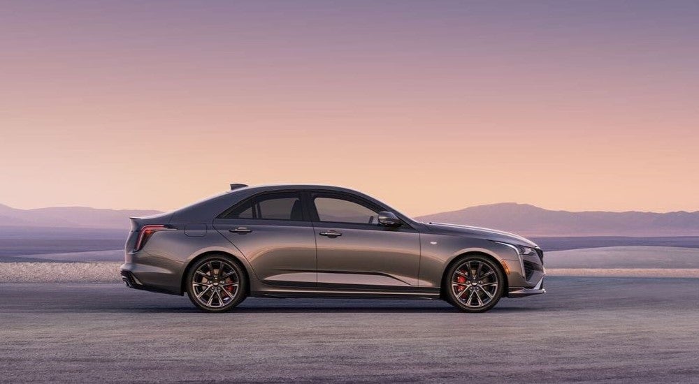 A grey 2024 Cadillac CT4 is shown from the side after leaving a New Ulm Cadillac dealer.