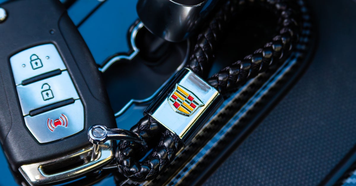 a key fob attached to a keychain with the Cadillac logo on it