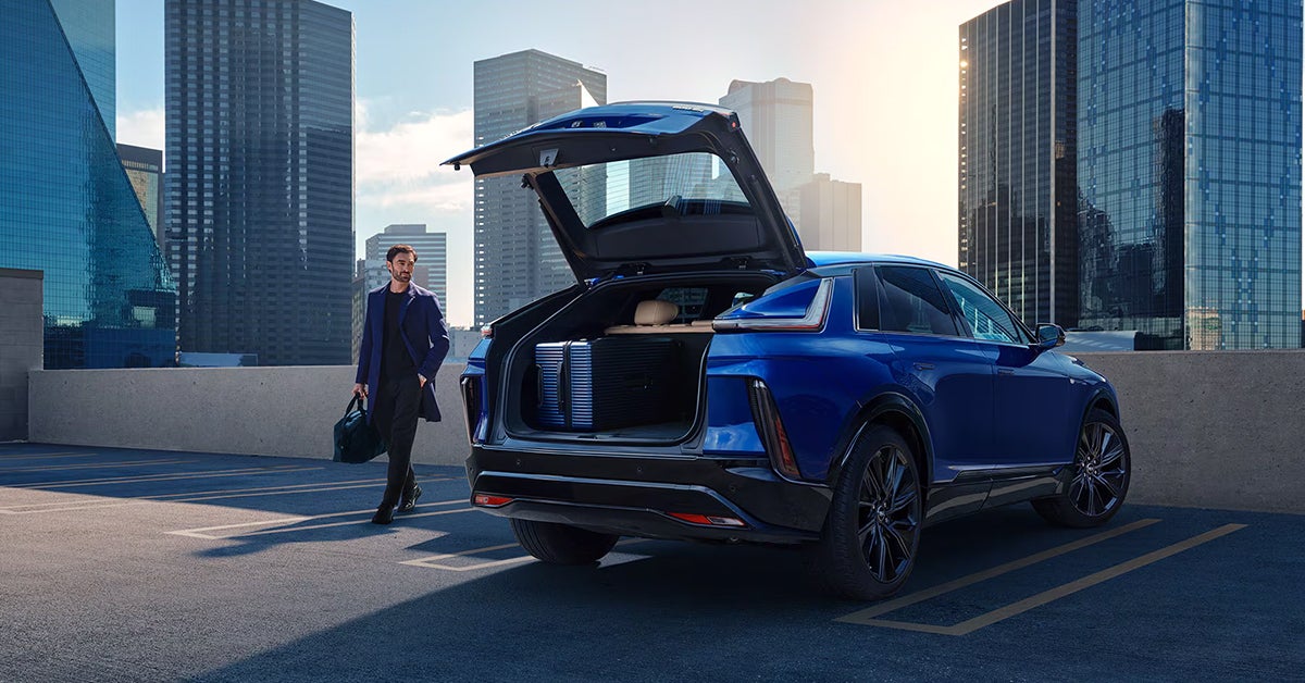 a man opening the trunk of a 2025 Cadillac LYRIQ in a parking lot