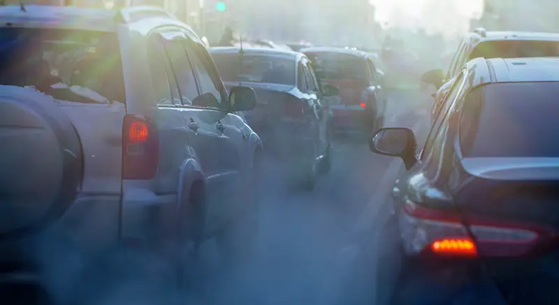 cars driving with smoke coming out of exhaust