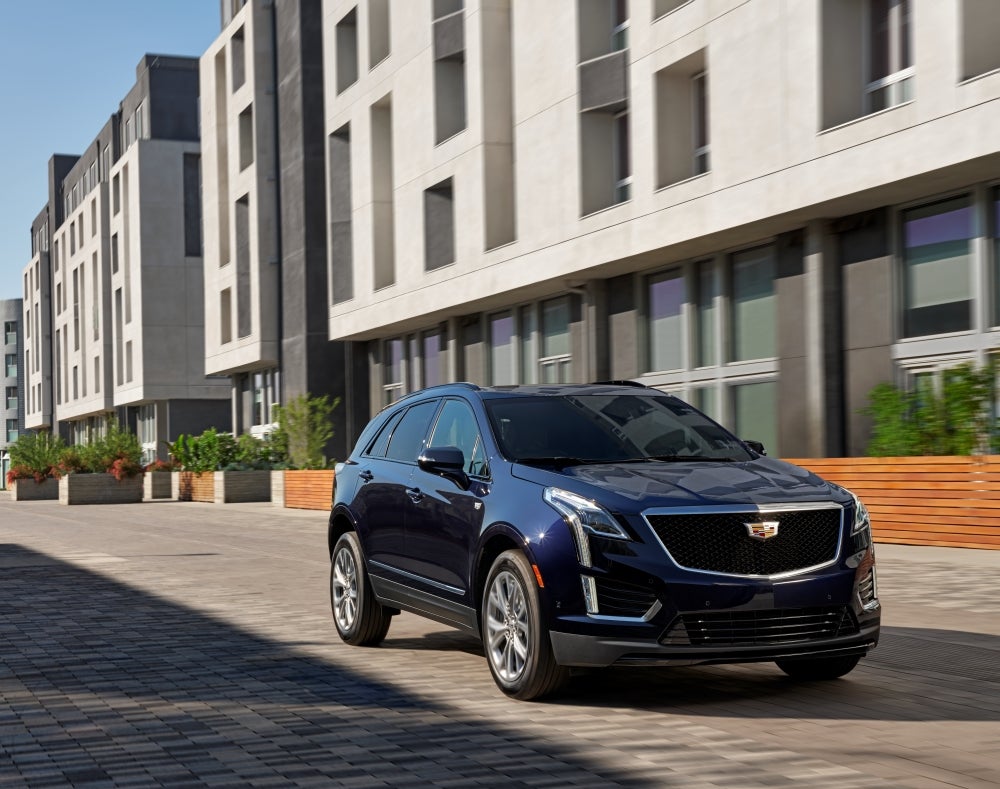 Cadillac 2026 XT5 Sport in Dark Blue Moon Metallic parked in front of city building