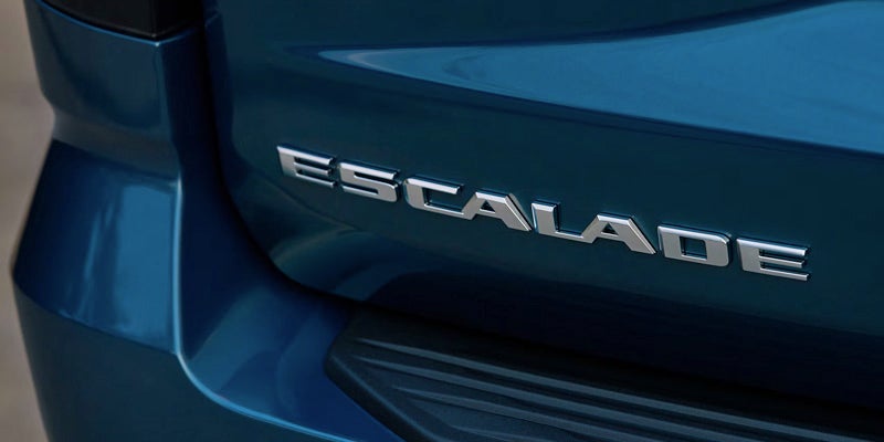 Cadillac Escalade rear badge with chrome lettering on a blue vehicle