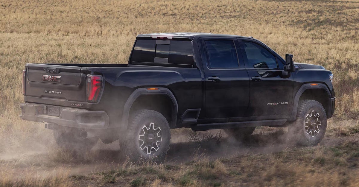 2026 GMC Sierra HD - Driving off-road through a grassy field