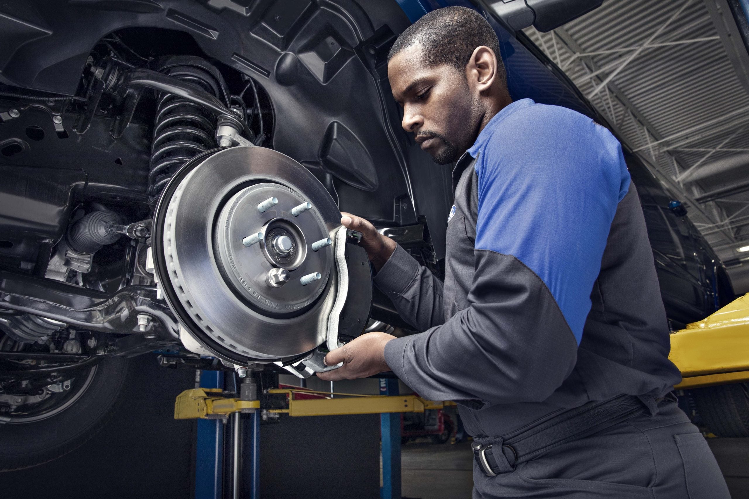A mechanic installing a brake disc on a car