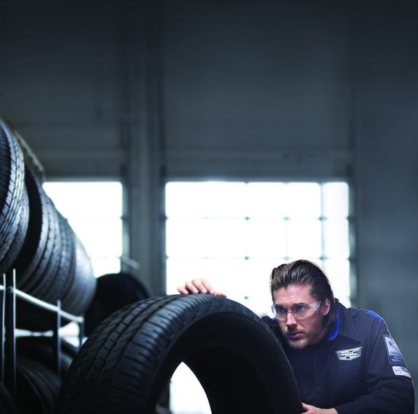 technician inspecting tread on a tire