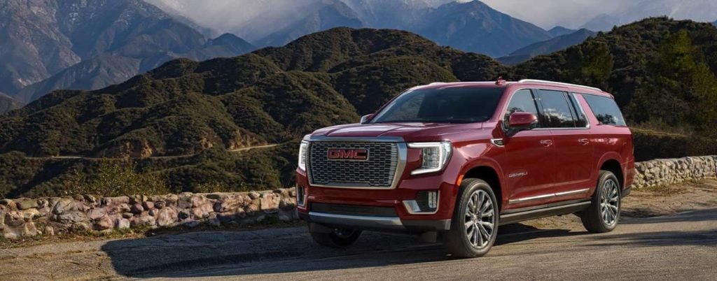 A red 2024 GMC Yukon XL for sale is shown at an overlook.