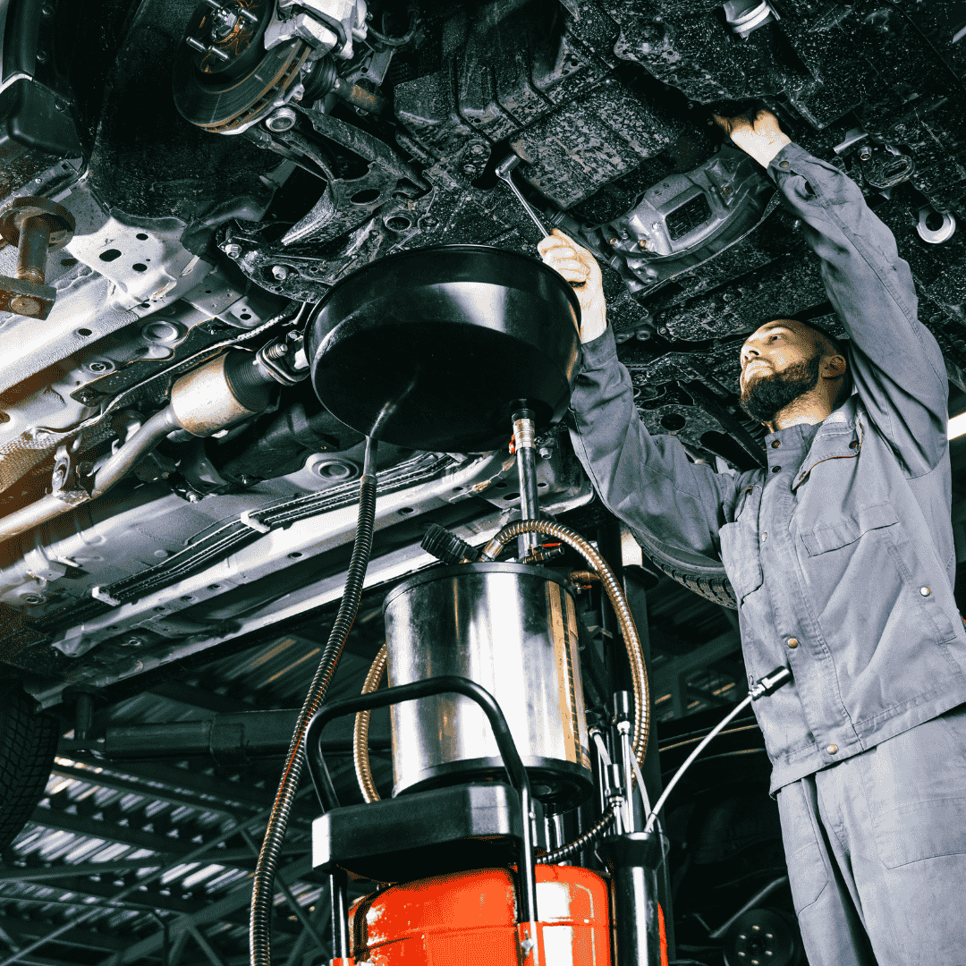 Technician inspecting a vehicle in a service bay
