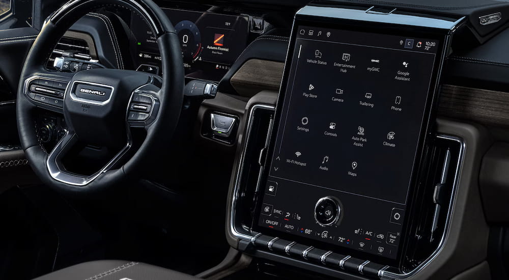 Close-up on the steering wheel and dashboard in the interior of a 2027 GMC Yukon.