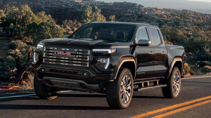 Black 2026 GMC Canyon Denali on a two-lane road; trade in your vehicle at Ross Downing GMC in Hammond, LA