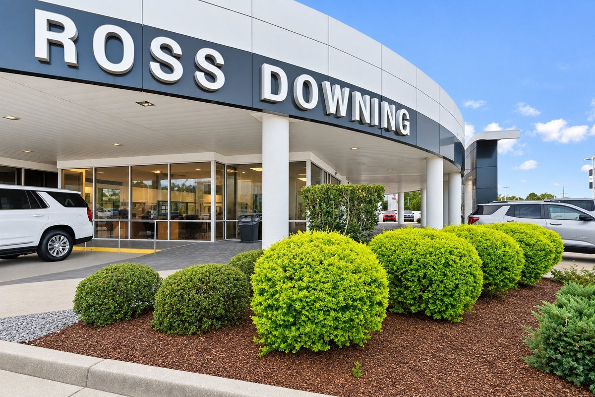 Front entrance of Ross Downing GMC in Hammond, LA with a GMC Yukon under the Ross Downing sign
