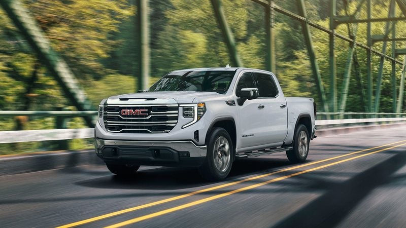 White 2026 GMC Sierra 1500 crossing a steel bridge; trade in your vehicle at Ross Downing GMC in Hammond, LA