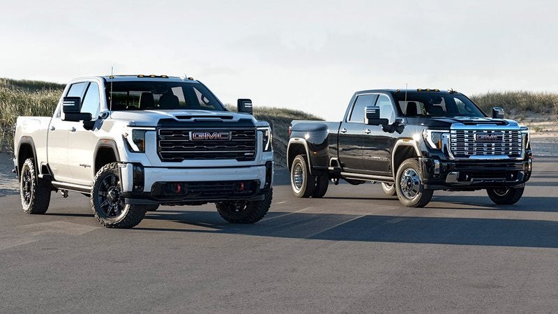 White and black 2026 GMC Sierra HD trucks parked side by side; GMC Sierra 2500 HD financing at Ross Downing GMC in Hammond, LA