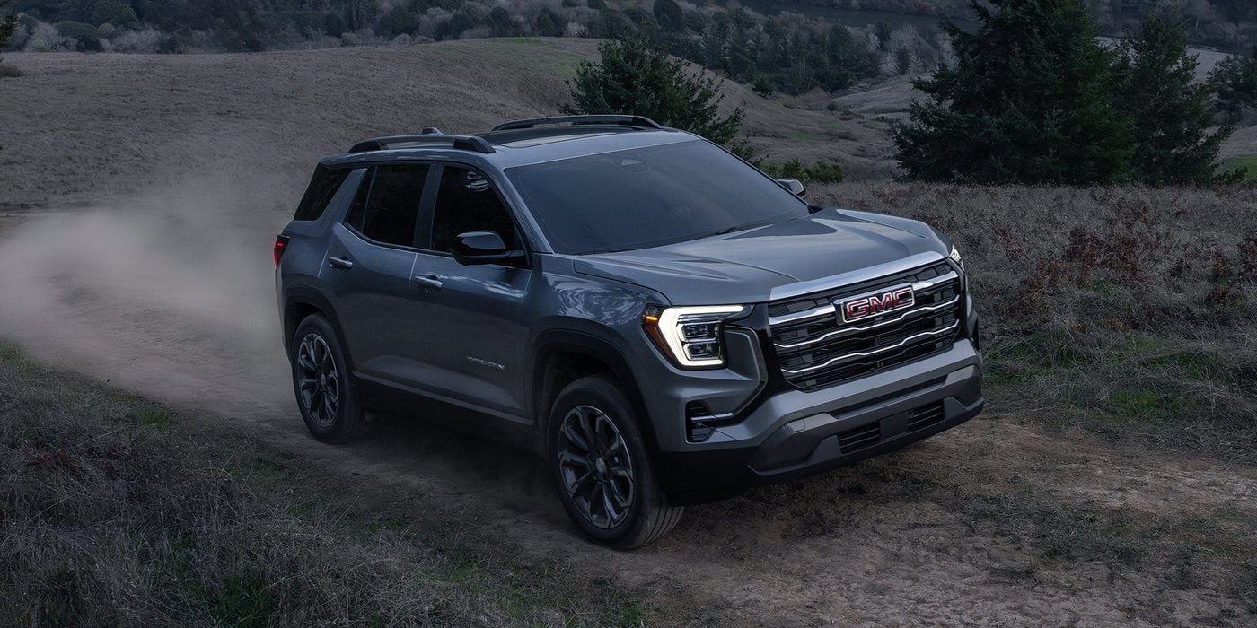 Gray 2027 GMC Terrain Elevation driving on a dirt trail; GMC Terrain AWD and MPG at Ross Downing GMC in Hammond, LA