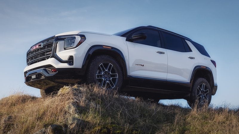 White 2027 GMC Terrain AT4 perched on a grassy rise; GMC Terrain financing at Ross Downing GMC in Hammond, LA