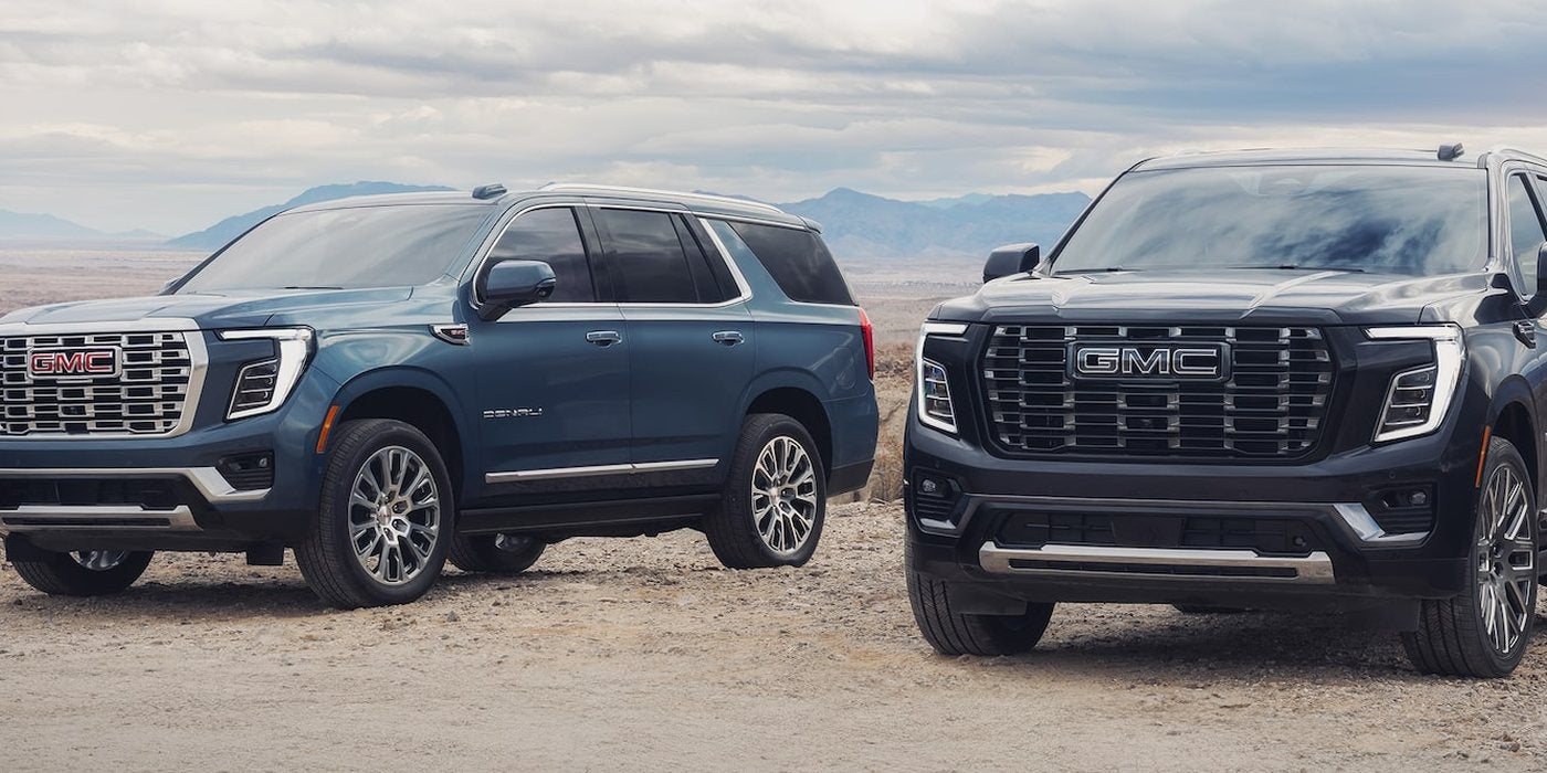 Blue and black 2026 GMC Yukon Denali models parked side by side, both sold new at Ross Downing GMC in Hammond, LA