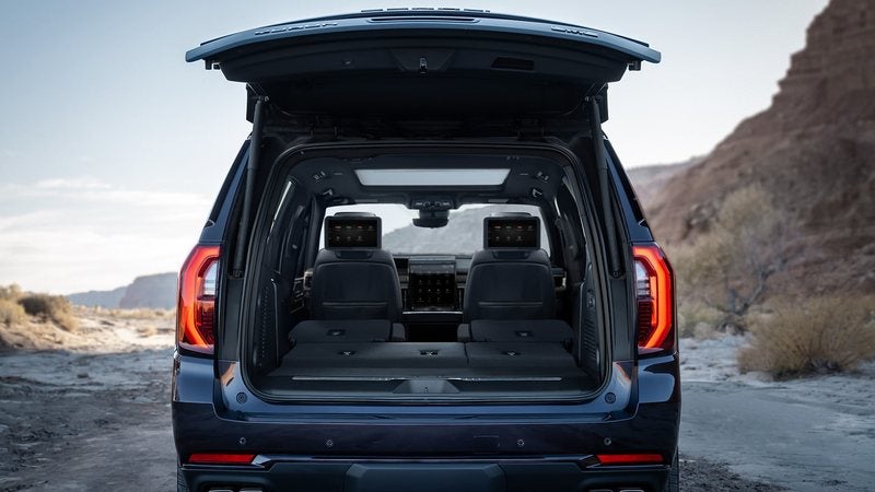 2026 GMC Yukon with its liftgate open beside a desert stream; trade in your vehicle at Ross Downing GMC in Hammond, LA