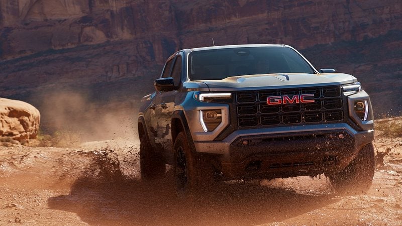 Gray 2026 GMC Canyon Elevation kicking up red dirt on a desert trail; GMC Canyon financing at Ross Downing GMC in Gonzales, LA