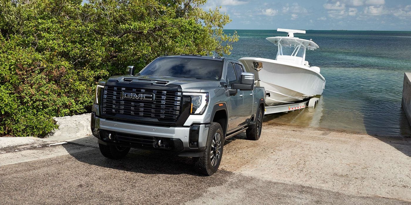 Gray 2026 GMC Sierra 2500 HD Denali pulling a fishing boat up a coastal launch ramp, at Ross Downing GMC in Gonzales, LA