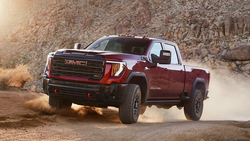 Red 2026 GMC Sierra 2500 HD AT4X driving off-road; trade in your vehicle at Ross Downing GMC in Gonzales, LA