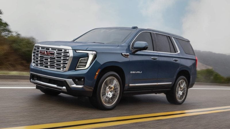 Blue 2027 GMC Yukon on a wet highway; GMC Yukon financing at Ross Downing GMC in Gonzales, LA