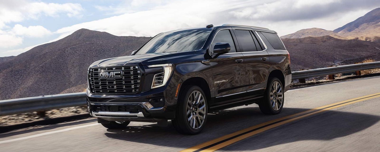 Black 2027 GMC Yukon on a winding mountain road; new GMC Yukon SUVs for sale at Ross Downing GMC in Gonzales, LA