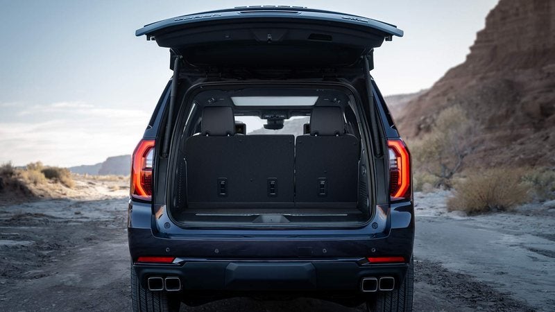 2027 GMC Yukon with its liftgate open beside a desert stream; trade in your vehicle at Ross Downing GMC in Gonzales, LA