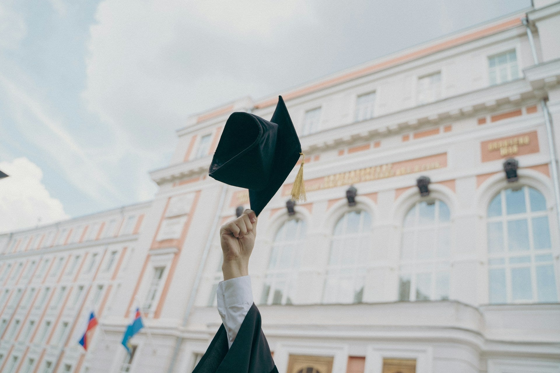 Hand holding graduation cap
