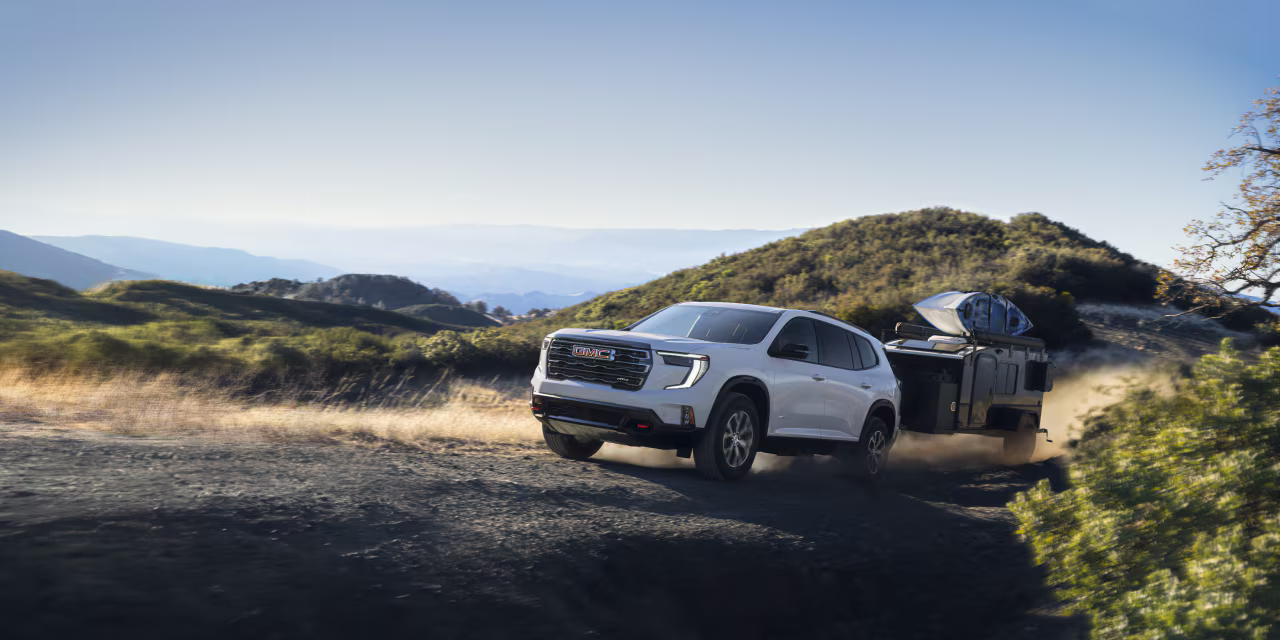 A new GMC Acadia pulling a trailer