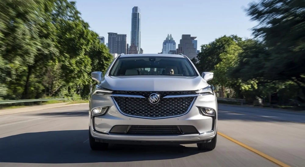 Silver 2022 Buick Enclave Avenir driving on a city street