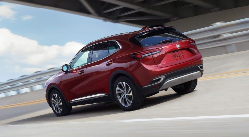Red 2023 Buick Envision driving under a bridge