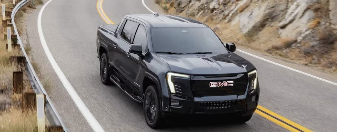 A black 2026 GMC Sierra EV Elevation driving on a highway.