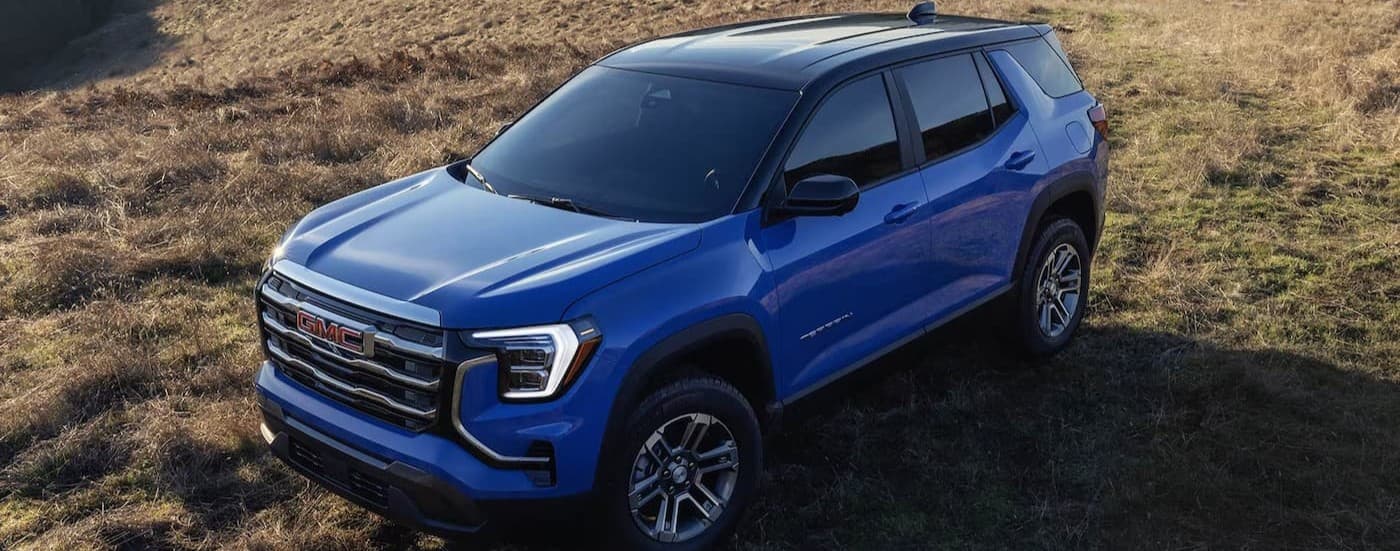 A blue 2026 GMC Terrain parked on grass.