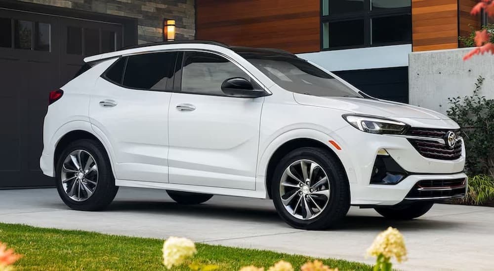 A white 2023 Buick Encore GX parked near a garage.