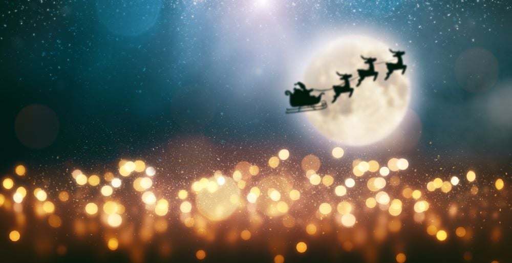 Santa and reindeer flying in front of moon