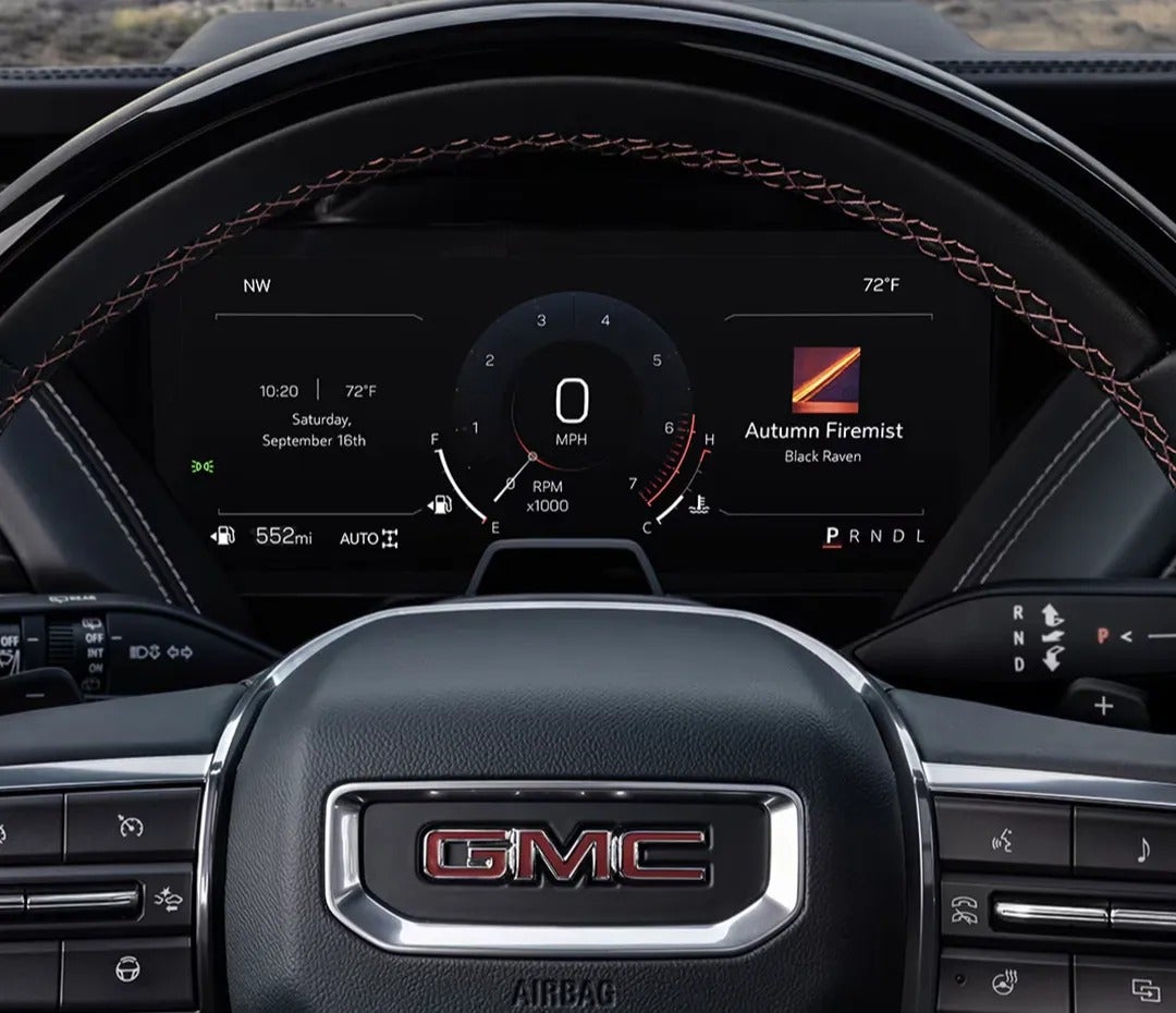Behind the wheel of a 2025 GMC SUVs steering wheel and driver dashboard