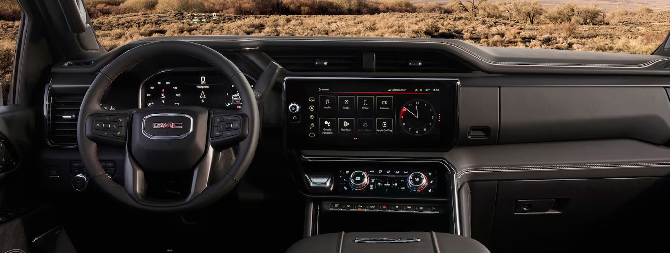 2026 GMC Sierra 2500 HD AT4 navigating off-road terrain showing suspension lift and skid plates