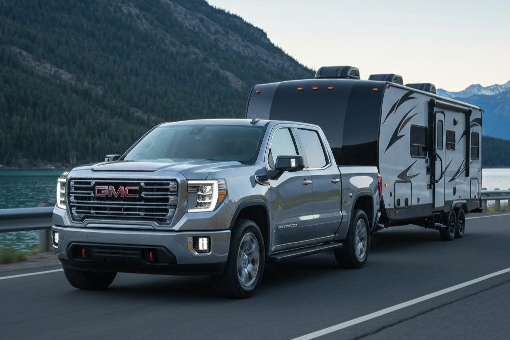 GMC Sierra towing a camper through a mountainous road