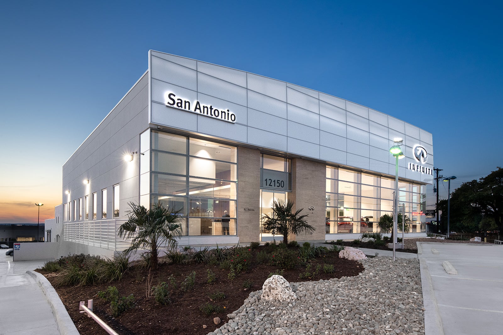 Modern INFINITI dealership building in San Antonio with large windows and landscaping.