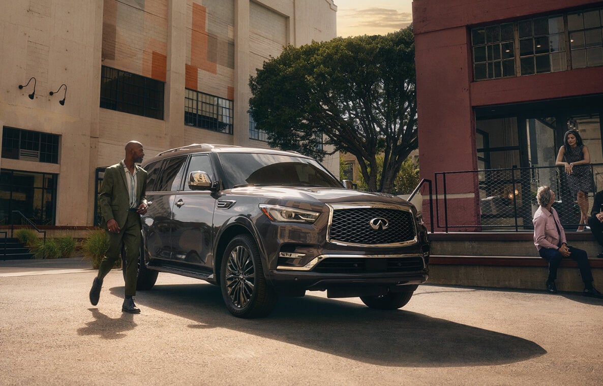INFINITI SUV parked outside with people nearby