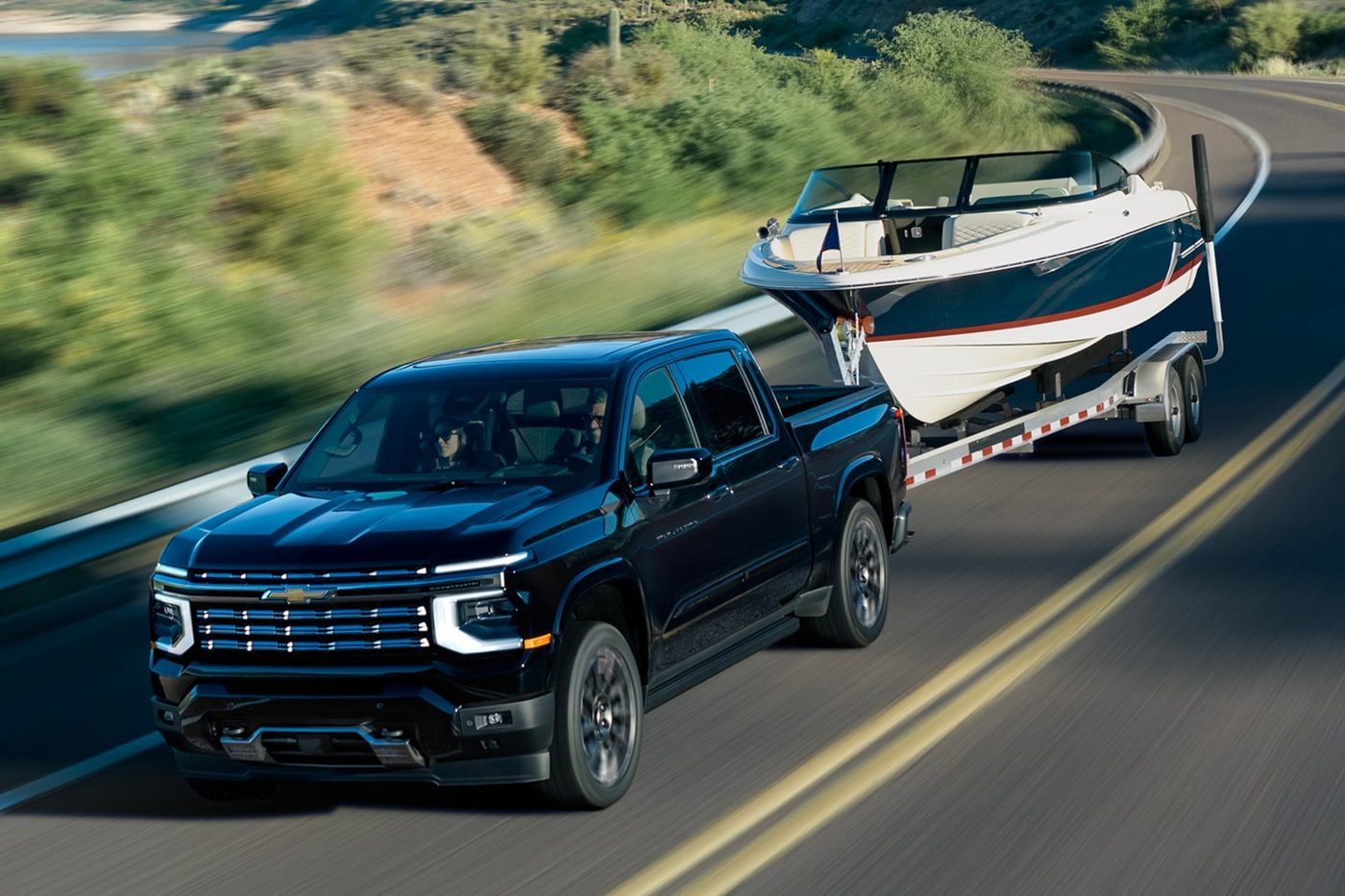 Black 2027 Chevy Silverado 1500 towing a boat, the next-generation Silverado at Ross Downing Chevrolet in Hammond, LA