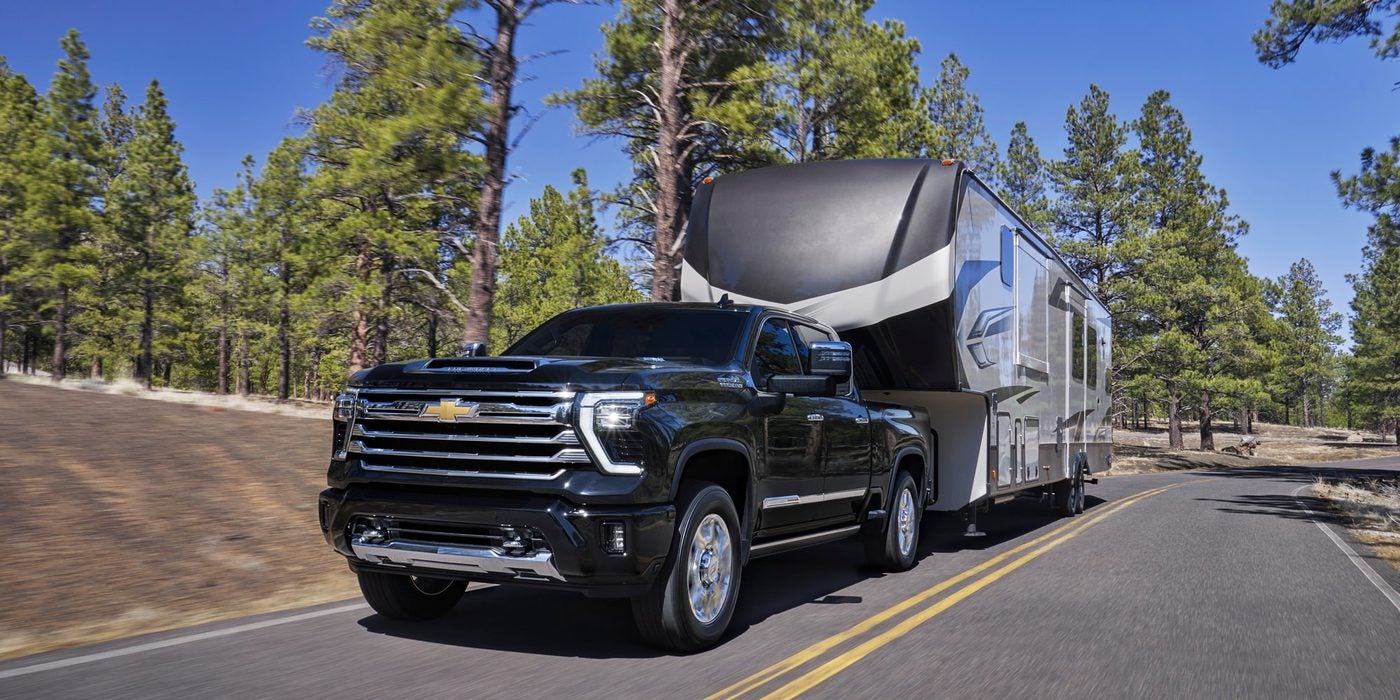 2026 Chevy Silverado HD High Country towing a fifth-wheel trailer