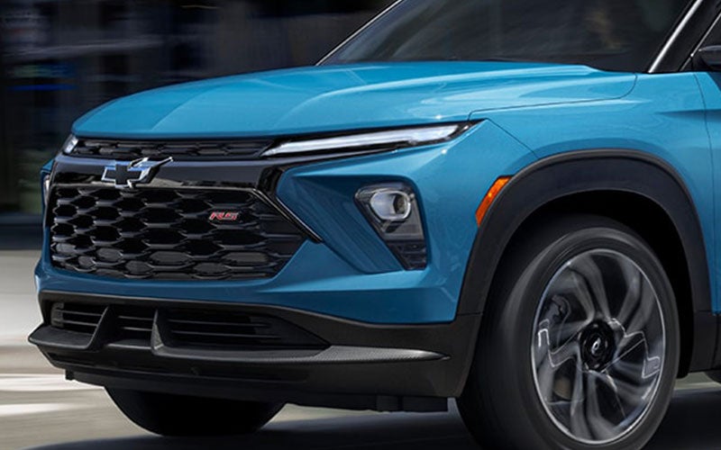 Close-up of a blue Chevrolet SUV's front grille and headlights